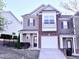 Charming two-story townhome showcasing a brick facade, attached garage, and manicured landscaping at 743 Silver Stream Ln, Cary, NC 27519