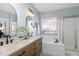 Bright bathroom featuring double vanity, separate soaking tub and enclosed shower with glass door at 756 Rockville Rd, Wake Forest, NC 27587