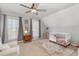 Cozy Bedroom with soft lighting, a ceiling fan, comfortable seating, and neutral decor at 756 Rockville Rd, Wake Forest, NC 27587