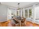 Light-filled dining area featuring large windows, hardwood floors, and a rustic dining set at 756 Rockville Rd, Wake Forest, NC 27587