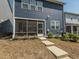 A blue house with a screened porch and small landscaped yard and a concrete step path leading to the porch at 781 Cormiche Ln, Wake Forest, NC 27587