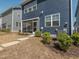 A blue house with a screened porch and small landscaped yard and a concrete step path leading to the porch at 781 Cormiche Ln, Wake Forest, NC 27587