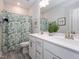 Stylish bathroom with double vanity, decorative mirror, and a shower-tub combo with leafy green curtain at 781 Cormiche Ln, Wake Forest, NC 27587