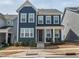 Charming blue two-story home featuring a covered front porch and well-manicured landscaping at 781 Cormiche Ln, Wake Forest, NC 27587
