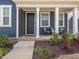 Inviting covered porch with chairs, plants, and charming details on this two-story blue home at 781 Cormiche Ln, Wake Forest, NC 27587