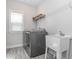 Well-lit laundry room with washer, dryer, utility sink, and shelving at 781 Cormiche Ln, Wake Forest, NC 27587