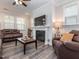 Inviting living room featuring a fireplace, ceiling fan, and comfortable leather seating, ideal for gatherings at 781 Cormiche Ln, Wake Forest, NC 27587