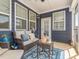 Screened in back porch features a cozy seating area with a wicker couch, pillows, rug, and decor at 781 Cormiche Ln, Wake Forest, NC 27587