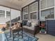 Screened in back porch features a cozy seating area with a wicker couch, pillows, rug, and decor at 781 Cormiche Ln, Wake Forest, NC 27587