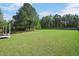 Expansive backyard featuring lush green grass and mature trees, perfect for outdoor activities at 8016 Parker Mill Trl, Fuquay Varina, NC 27526