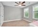 Bedroom with a ceiling fan, two windows, carpet flooring, and view of closet at 8016 Parker Mill Trl, Fuquay Varina, NC 27526