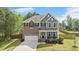 Charming two-story home with a brick and gray siding exterior, covered porch, and well-manicured lawn at 8016 Parker Mill Trl, Fuquay Varina, NC 27526