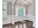 Bright foyer with a transom window door, beautiful moulding, dark wood floors, and a modern light fixture at 8016 Parker Mill Trl, Fuquay Varina, NC 27526
