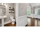 Charming hallway leading to a half bathroom with a pedestal sink and decorative shelving at 8016 Parker Mill Trl, Fuquay Varina, NC 27526
