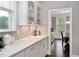 Kitchen with white cabinets and countertops, tile backsplash, and natural light from a nearby window at 8016 Parker Mill Trl, Fuquay Varina, NC 27526