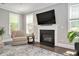 Cozy living room featuring a fireplace, large windows, and hardwood floors at 8016 Parker Mill Trl, Fuquay Varina, NC 27526