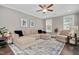 Comfortable living room with a large sectional sofa, stylish rug, and ample natural light at 8016 Parker Mill Trl, Fuquay Varina, NC 27526