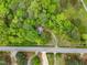 Aerial view of treed acreage surrounded by lush greenery near a road at 8175 Nc 27 E, Coats, NC 27521