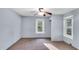 Neutral bedroom featuring a ceiling fan, carpet, and well-lit windows at 8175 Nc 27 E, Coats, NC 27521