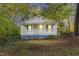 A quaint one-story home with a covered porch, offering a peaceful retreat surrounded by nature at 8175 Nc 27 E, Coats, NC 27521