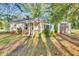 A quaint home with a covered porch and a small storage shed, blending charm with practical storage solutions at 8175 Nc 27 E, Coats, NC 27521