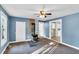 Comfortable living room featuring a classic ceiling fan, wood-burning stove, and adjacent doorway at 8175 Nc 27 E, Coats, NC 27521