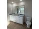 Bathroom with granite countertop, dual sinks, toilet, and view of the bathtub in the mirror at 87 Heatherglenn Cir, Princeton, NC 27569