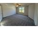 Spacious bedroom with neutral color scheme, plush carpeting, a ceiling fan, and a large window offering ample natural light at 87 Heatherglenn Cir, Princeton, NC 27569