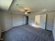 Primary bedroom featuring plush carpeting, a tray ceiling with fan, and an ensuite bathroom at 87 Heatherglenn Cir, Princeton, NC 27569