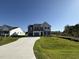 Spacious two-story home with a three car garage and a long driveway on a large lot under a cloudless blue sky at 87 Heatherglenn Cir, Princeton, NC 27569