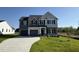 Charming two-story home with a three car garage and a well-manicured lawn under a bright blue sky at 87 Heatherglenn Cir, Princeton, NC 27569