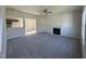 Open living room featuring plush carpeting, a cozy fireplace, and an open floor plan leading to the kitchen at 87 Heatherglenn Cir, Princeton, NC 27569