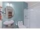 Fresh bathroom features a glass shower, modern toilet, and round mirror over the sink at 8812 Forester Ln, Apex, NC 27539