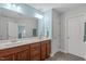 Well-lit bathroom with dual sinks, wood cabinets, and a large mirror offering great functionality at 8812 Forester Ln, Apex, NC 27539