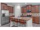 This kitchen features granite counters, stainless appliances, and three stools at the breakfast bar at 8812 Forester Ln, Apex, NC 27539