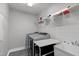 Laundry room with stainless steel washer and dryer, sink, and overhead shelving for easy organization at 8812 Forester Ln, Apex, NC 27539