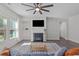 Comfortable living room with a fireplace, mounted television, and bright lighting at 8812 Forester Ln, Apex, NC 27539