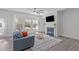 Living room with fireplace, ceiling fan, and lots of natural light at 8812 Forester Ln, Apex, NC 27539
