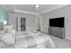 Serene main bedroom with large TV, ensuite access, and soft, neutral colors for a relaxing retreat at 8812 Forester Ln, Apex, NC 27539