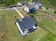 A bird's-eye view of the back of the house, featuring a porch, a well-kept lawn, and verdant trees at 9220 Yardley Town Dr, Wake Forest, NC 27587