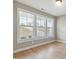 Bedroom with three windows letting in natural light and hardwood floors at 9220 Yardley Town Dr, Wake Forest, NC 27587