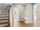 Entryway featuring a coat rack with storage bench, wood floors and staircase to the left at 9220 Yardley Town Dr, Wake Forest, NC 27587