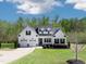 Charming two-story white farmhouse with black shutters, three-car garage, and lush green lawn at 9220 Yardley Town Dr, Wake Forest, NC 27587
