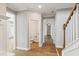 Hallway with hardwood floors, white trim and neutral paint, and a view into the powder room at 9220 Yardley Town Dr, Wake Forest, NC 27587