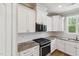 Modern kitchen features white cabinetry, granite countertops, and stainless steel appliances at 9220 Yardley Town Dr, Wake Forest, NC 27587