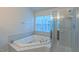 Bright bathroom featuring a soaking tub, separate shower, and a window with natural light at 9531 Vira Dr, Raleigh, NC 27617
