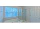Bright bathroom featuring a soaking tub, separate shower, and a window with natural light at 9531 Vira Dr, Raleigh, NC 27617
