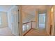 Upstairs hallway with neutral walls, carpeting, and wood railing overlooking the main level at 9531 Vira Dr, Raleigh, NC 27617