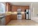 Well-equipped kitchen featuring stainless steel appliances, wooden cabinetry, and a seamless flow to the dining area at 9531 Vira Dr, Raleigh, NC 27617