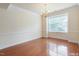 Bright, spacious living room featuring hardwood floors, a chandelier, and large window views at 9531 Vira Dr, Raleigh, NC 27617